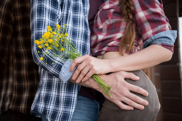 Casal apaixonado abraçando com flores — Fotografia de Stock