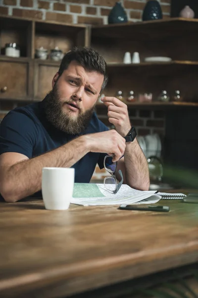 Müder Mann mit Zeitung auf dem Tisch — Stockfoto