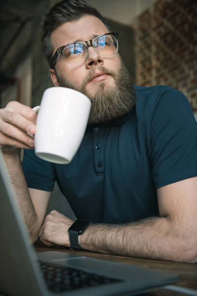 young bearded man drinking coffee