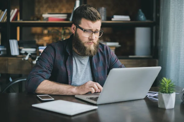 Uomo caucasico che lavora sul computer portatile a casa — Foto Stock