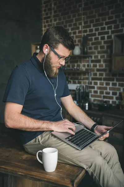 Casual homem usando laptop em casa Imagens Royalty-Free