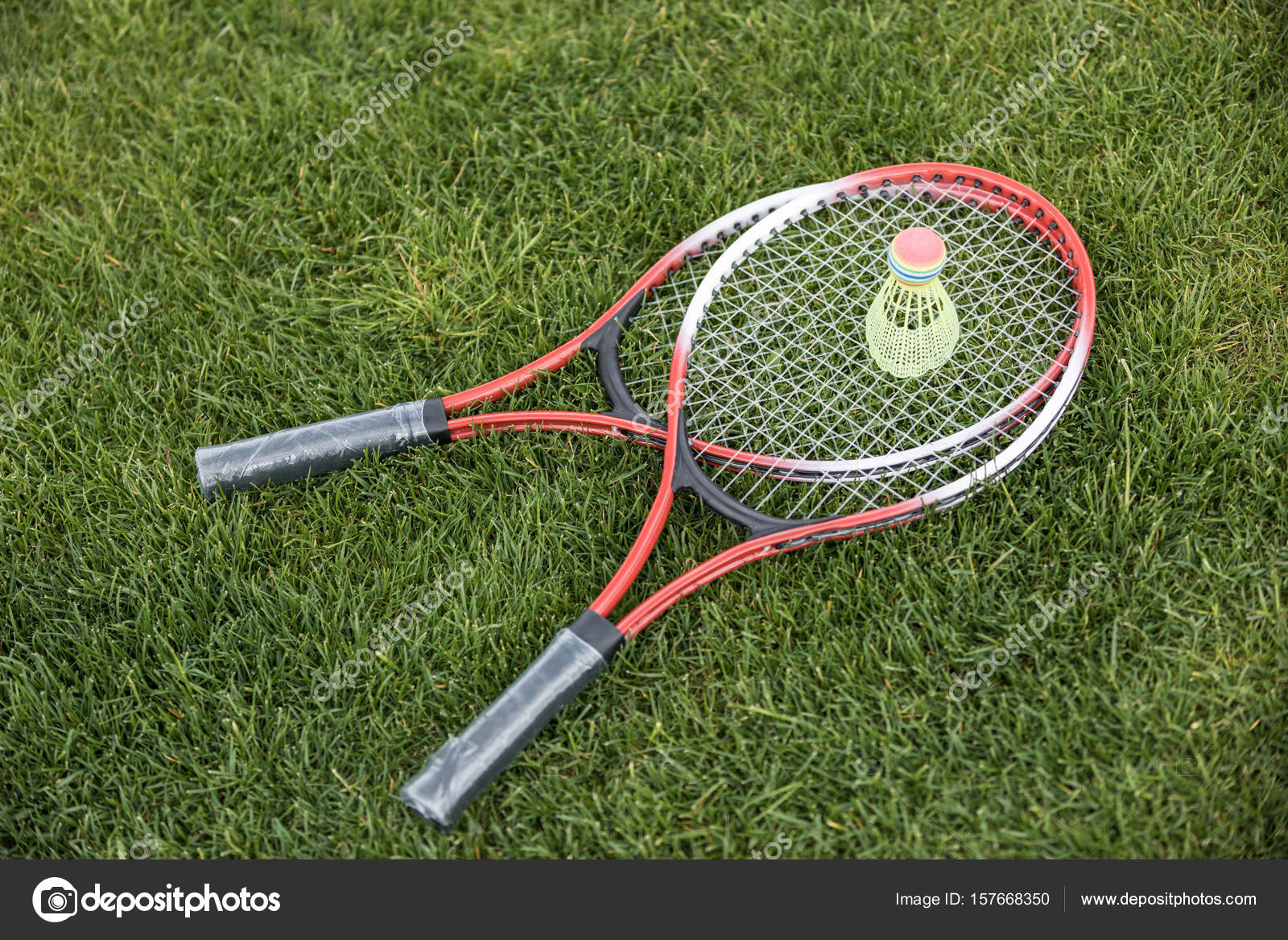Badminton racquets and shuttlecock on grass — Stock Photo