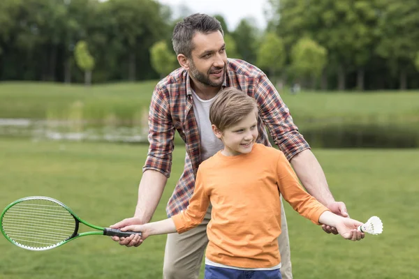 Otec učí syna hrát badminton — Stock fotografie