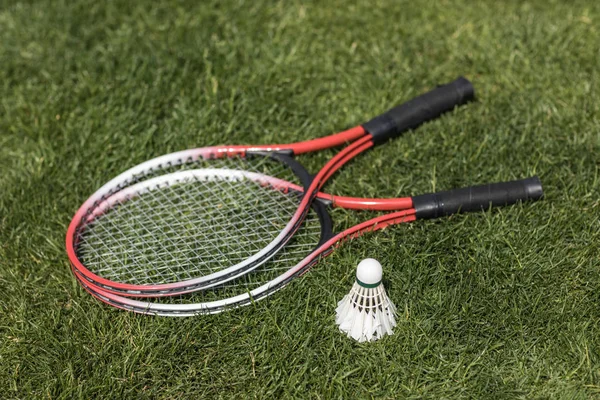 Badminton rackets met de shuttle op gras — Stockfoto