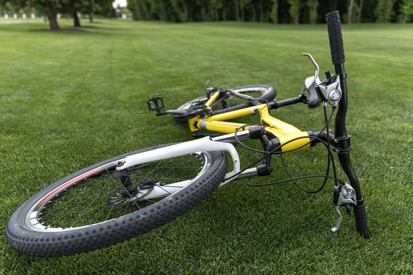 Bicicleta esporte deitado na grama no parque — Fotografia de Stock