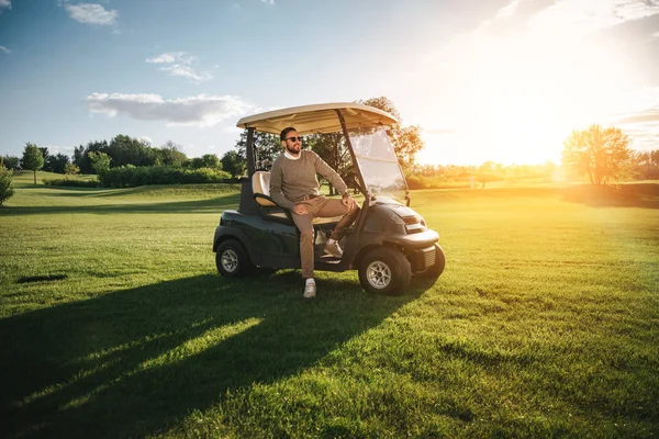 Hombre sentado en el coche de golf —  Fotos de Stock