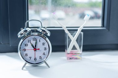 Alarm clock and toothbrushes in glass 3 clipart
