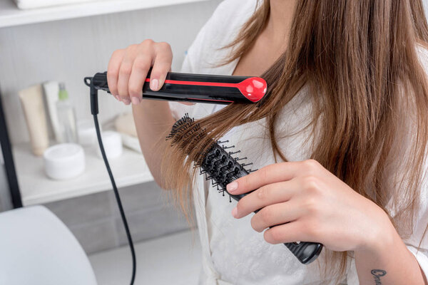 woman using hair straightener