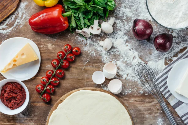 Pizza dough with ingredients — Stock Photo, Image