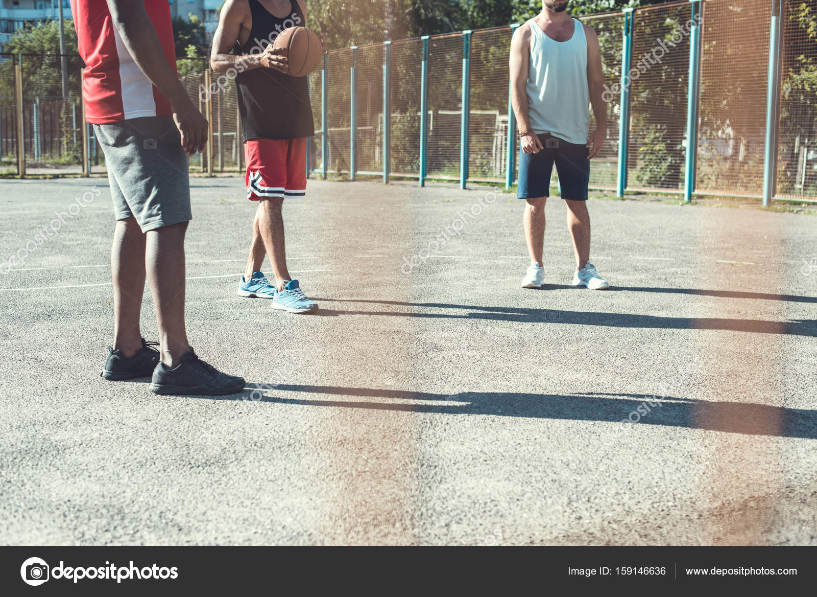 Grupo de pessoas multiétnicas jogando basquete na quadra