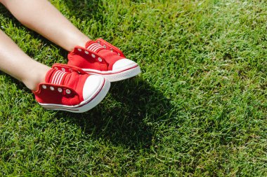 Child in sneakers on grass
