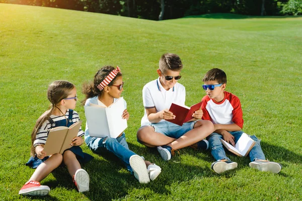 Crianças lendo livros no parque — Fotografia de Stock