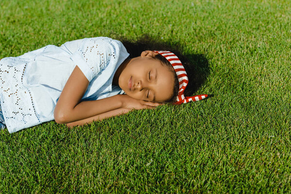 Африканская американка спит на траве
