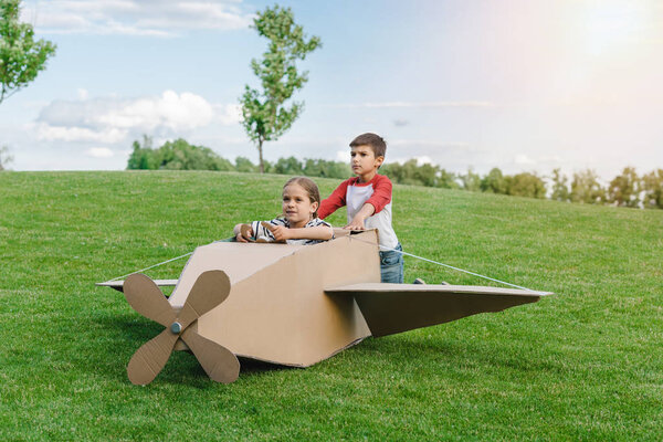 Дети играют с самолетом в парке
