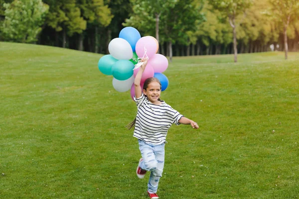 Pige med farverige balloner i parken - Stock-foto