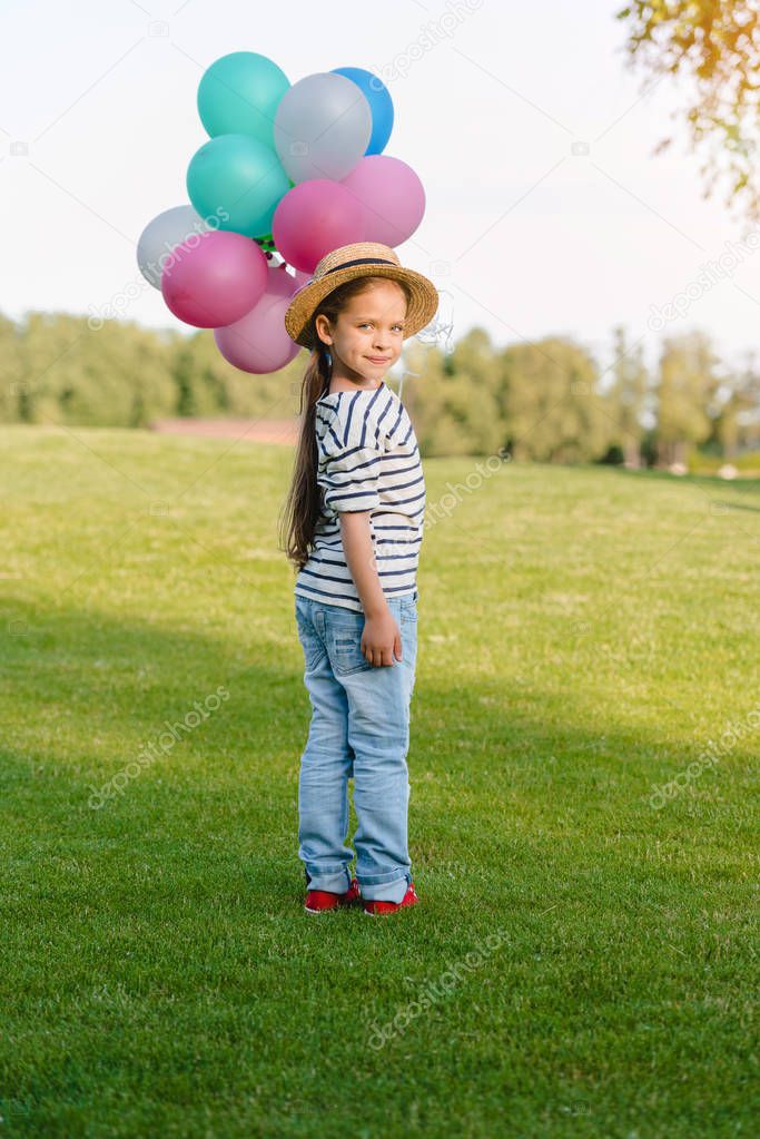 Girl with colorful balloons in park