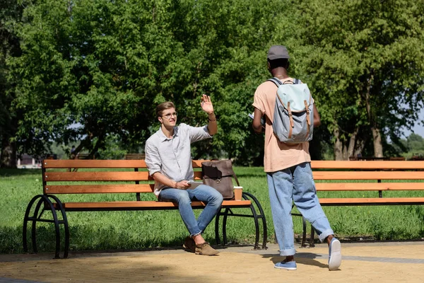 Man waving to friend in park — Stock Photo, Image