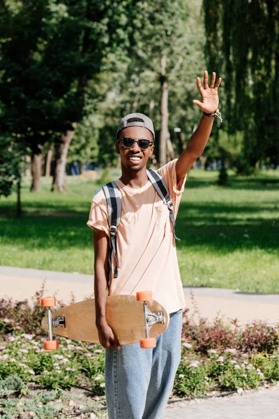 Hombre afroamericano con longboard — Foto de stock gratis