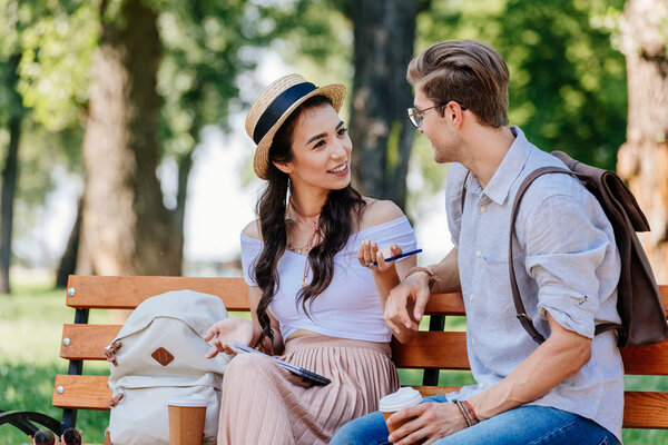 multicultural couple sitting on bench