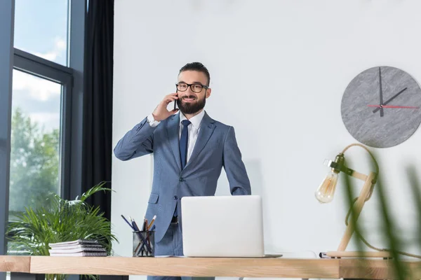 Zakenman praten over smartphone op werkplek — Stockfoto