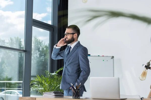 Empresário falando no smartphone no local de trabalho — Fotografia de Stock