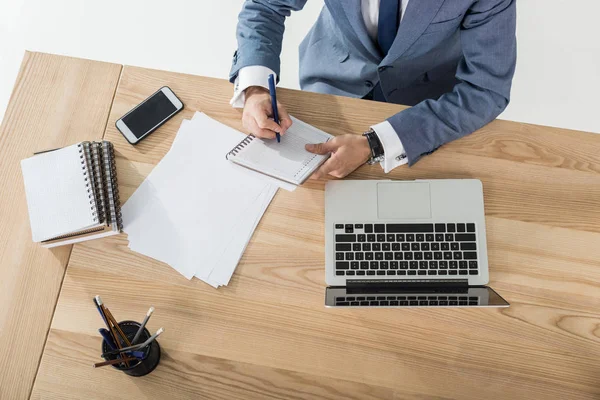 Zakenman schrijven in notitieblok op werkplek — Stockfoto