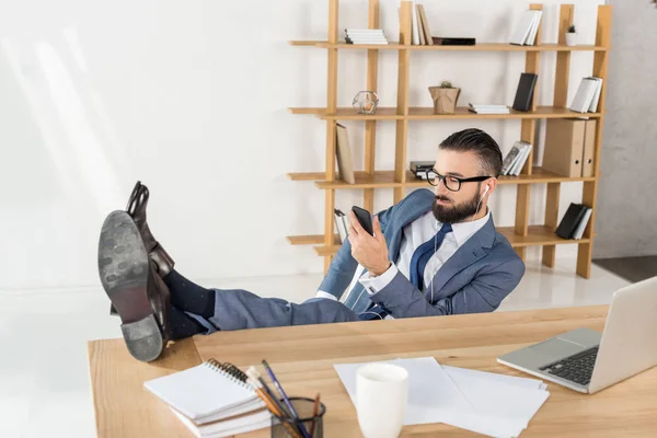 Zakenman luisteren muziek op werkplek — Stockfoto