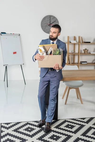 Fired upset businessman with cardboard box — Free Stock Photo