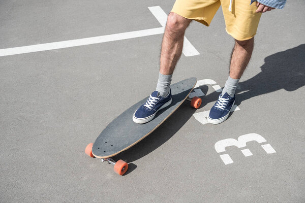 man standing on longboard