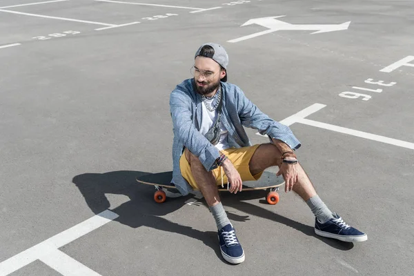 Homem sentado em longboard — Fotografia de Stock