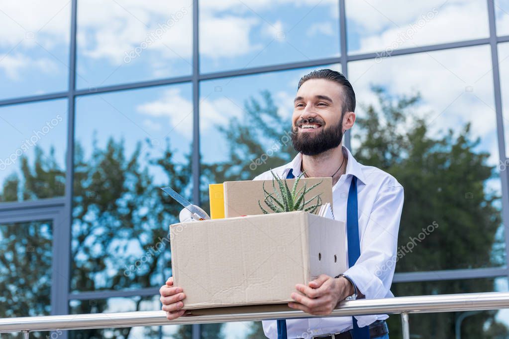 fired happy businessman with cardboard box