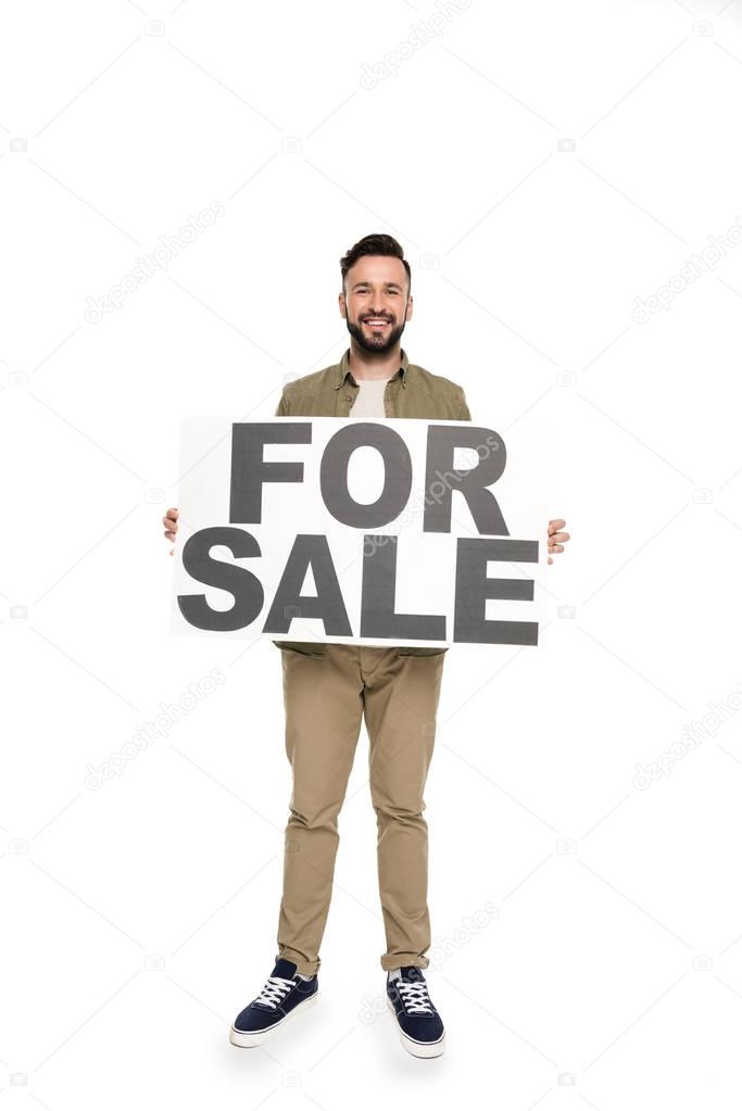Cheerful caucasian man holding for sale banner in hands isolated on white