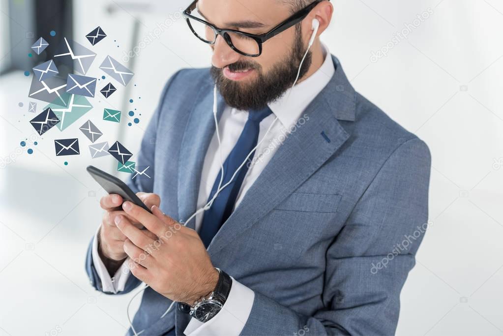 businessman in earphones using smartphone