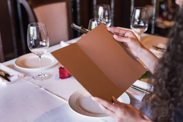 Vrouw met menu in restaurant — Stockfoto