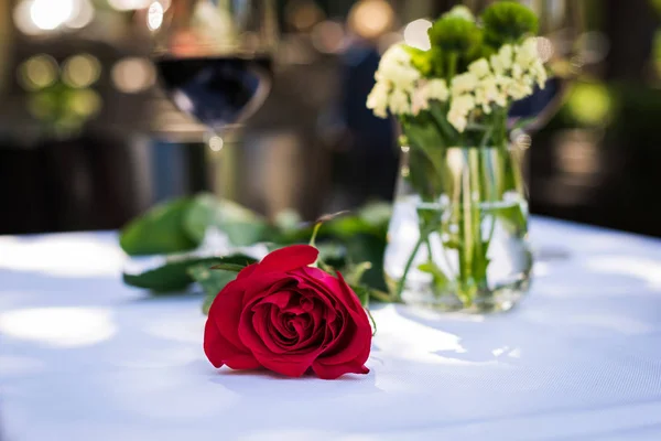 रेस्टॉरंटमध्ये टेबलवर वाईनसह गुलाब फूल — स्टॉक फोटो, इमेज