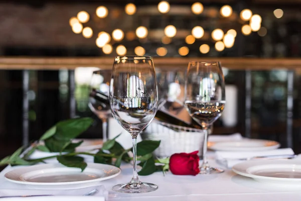 Fiore di rosa con vino a tavola nel ristorante Foto Stock Royalty Free