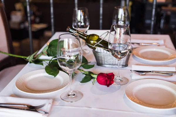 Rose flower with wine at table in restaurant Stock Picture