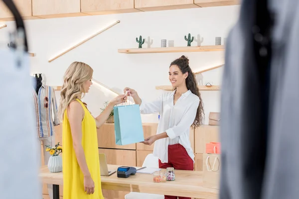 Cajero que da el bolso que dispara al cliente — Foto de Stock