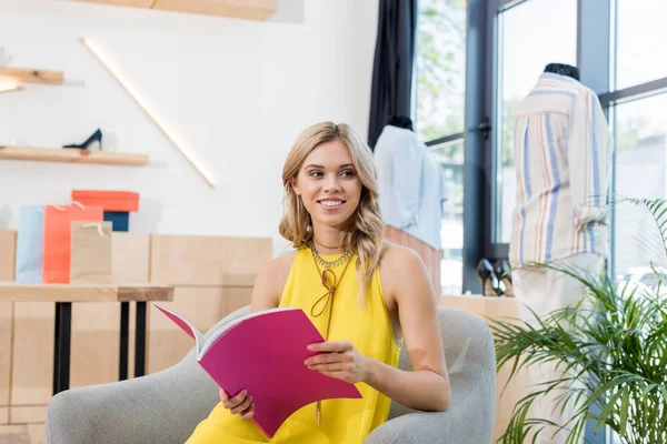 Woman reading magazine in showroom — Stock Photo, Image