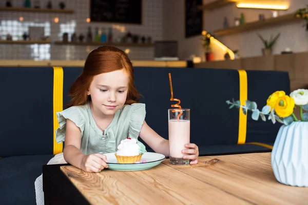 Flicka äter cupcake i café — Gratis stockfoto