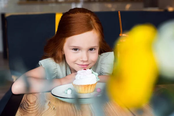Dívka jíst cukroví v kavárně — Stock fotografie