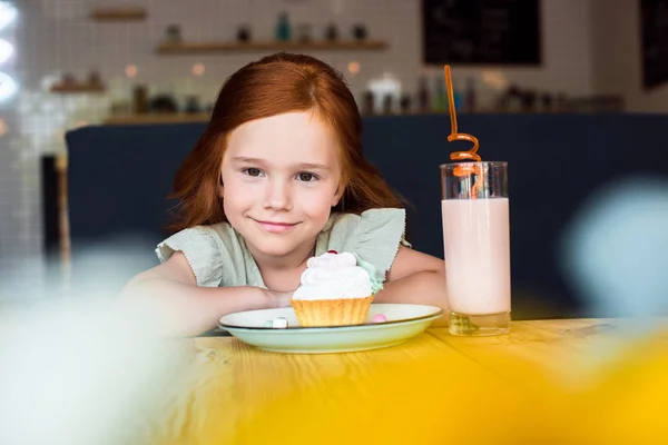 Girl with cupcake and milkshake in cafe — Stock Photo, Image