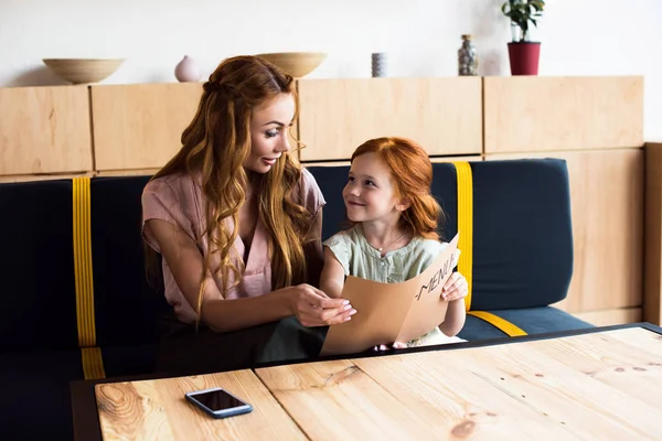 Mother and daughter reading menu in cafe — Stock Photo, Image