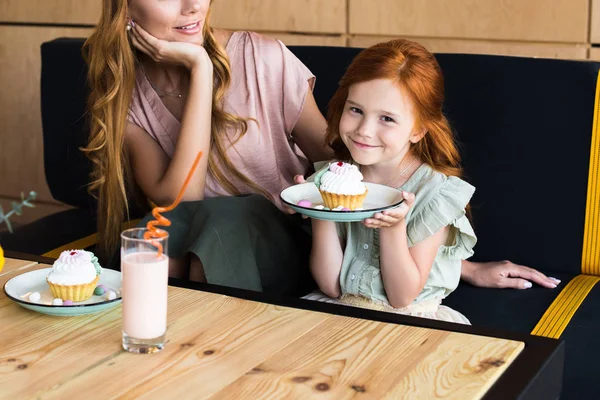 Matka a dcera jíst cupcakes — Stock fotografie