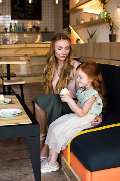 Мати і дочка з кексом в кафе — Безкоштовне стокове фото