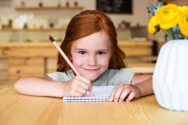 Menina ruiva desenho à mesa — Fotografia de Stock