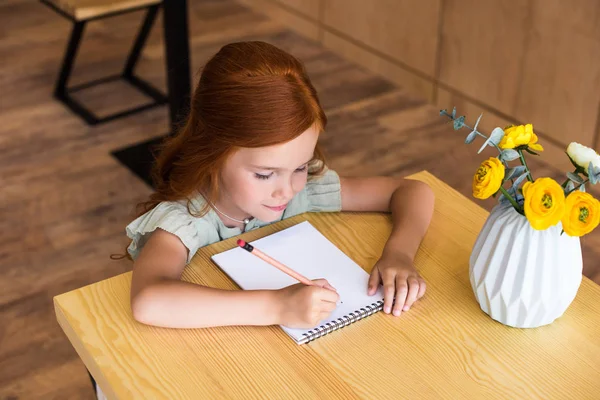 Redhead girl drawing at table — Stock Photo, Image