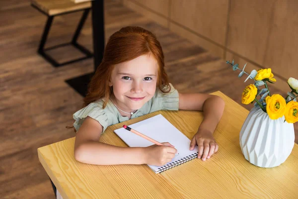 Redhead κορίτσι σχεδίασης στο τραπέζι — Φωτογραφία Αρχείου
