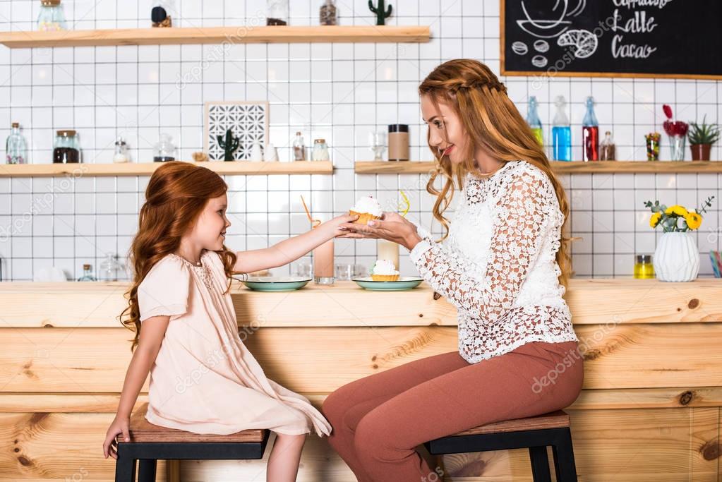 mother and daughter holding cupcake