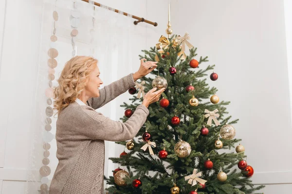 Woman decorating christmas tree — Stock Photo, Image